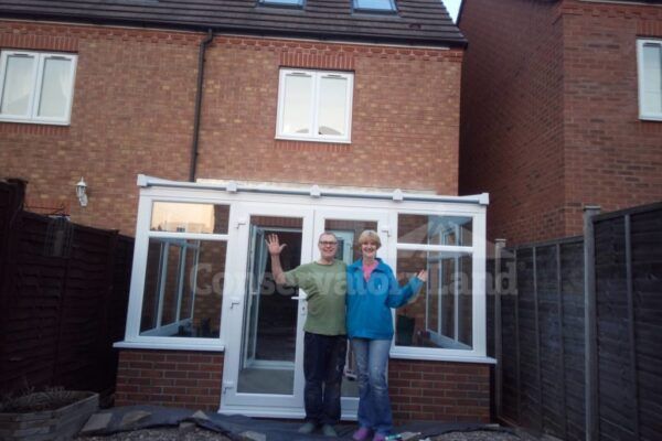 Mr and Mrs Baker standing outside their new DIY Conservatory
